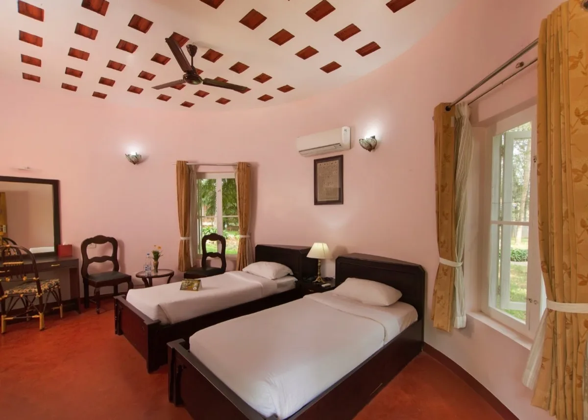 Twee aparte bedden in een roze slaapkamer van de Deluxe Villa