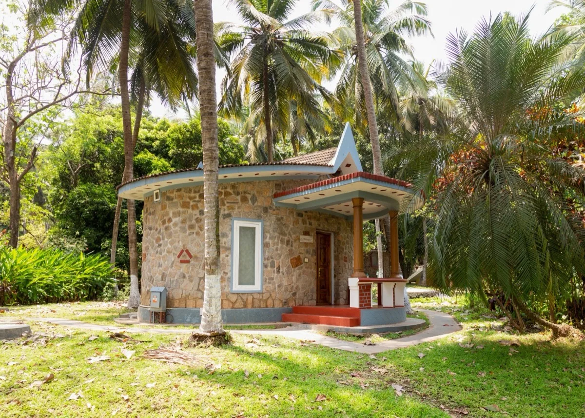 Buitenzijde van een stenen Deluxe Villa tussen palmbomen
