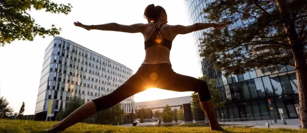 A person practising a standing yoga pose outdoors.
