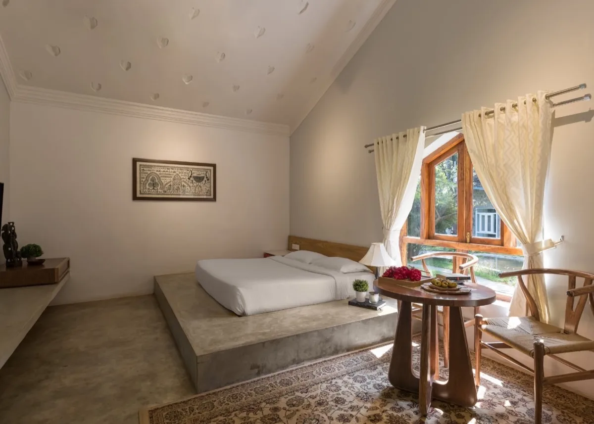 غرفة نوم وكراسٍ بجانب النافذة في Royal Villa