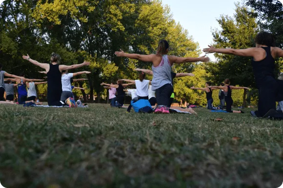Un gruppo che pratica yoga all'aperto tra gli alberi.