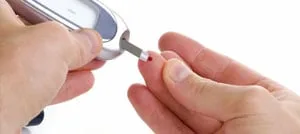 Un glucometro che preleva una goccia di sangue dalla punta di un dito