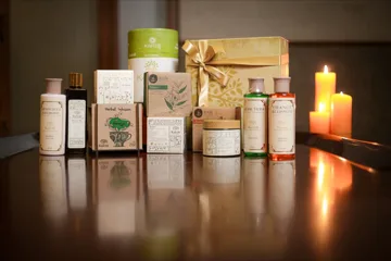 La gama completa de cuidado personal Kairali: lata de Kairtis; caja de regalo; Kairpack; pastillas de jabón de neem y de sándalo; Herbal Infusion; lociones