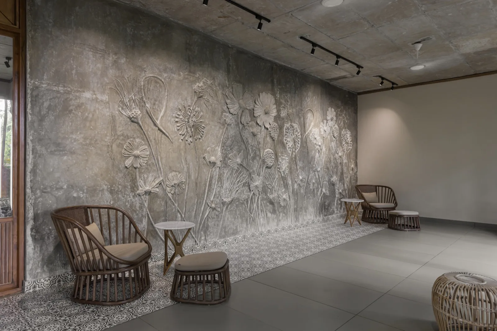 Sala d'attesa con un grande murale in rilievo a motivi botanici scolpito nell'intonaco cementizio