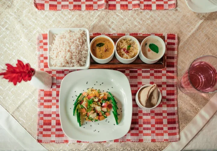 منظر علوي لطبق ثالي نباتي ساتفيكي يضم الأرز وأطباق الكاري والسلطة في Kairali